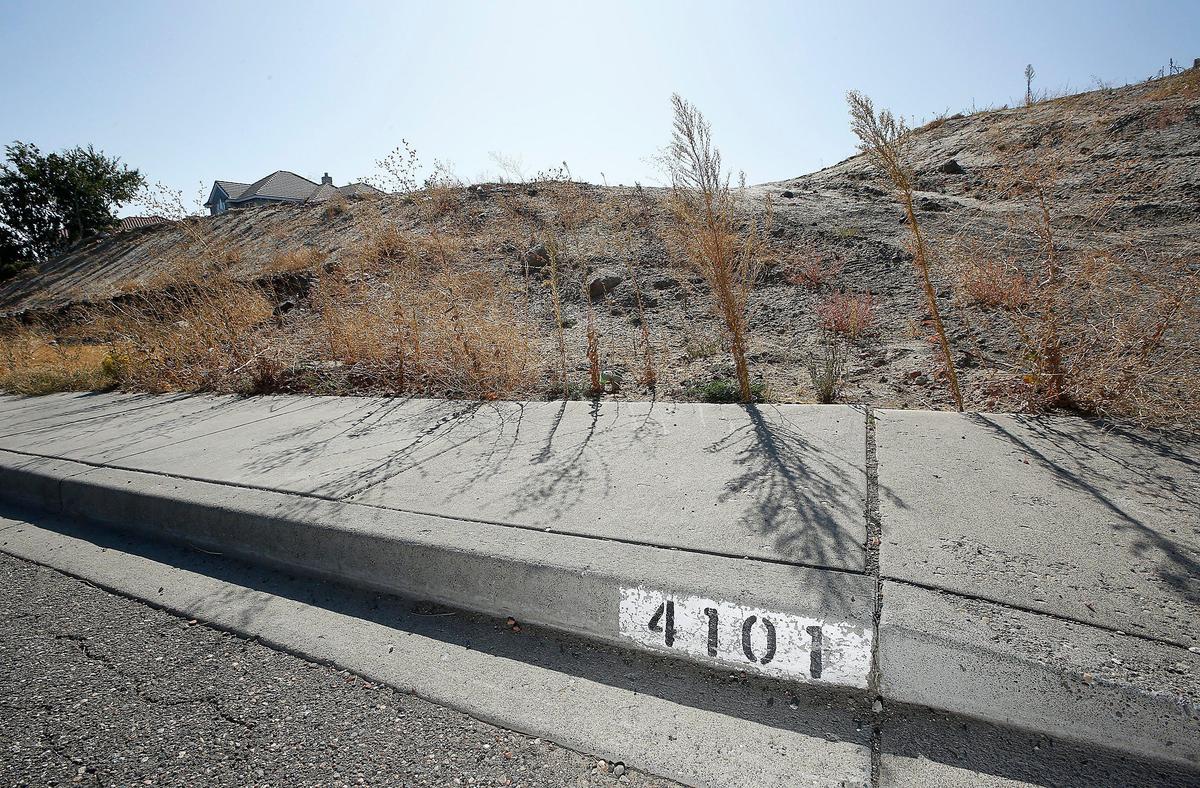 Painted address numbers on the curb are the only clue of where Rob and Sara Green’s home stood on West 43rd Avenue before the Bofer Canyon fire hit in the summer of 2018.