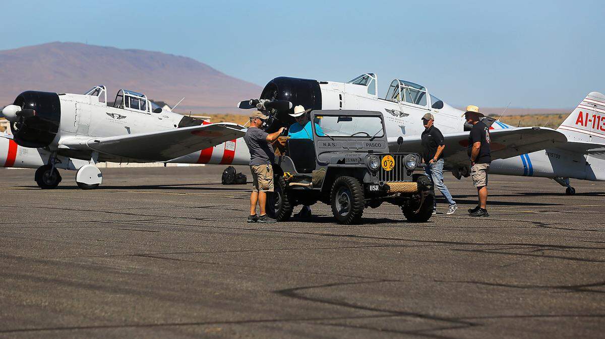 Pilots from the Tora Tora Tora Commemorative Air Force look at Scott Urban’s restored 1951 Navy Jeep Thursday morning on the tarmac of the Richland Airport. The group of six historic planes spent the night before refueling and taking off for their next airshow this weekend at Joint Base Lewis-McChord near Tacoma.