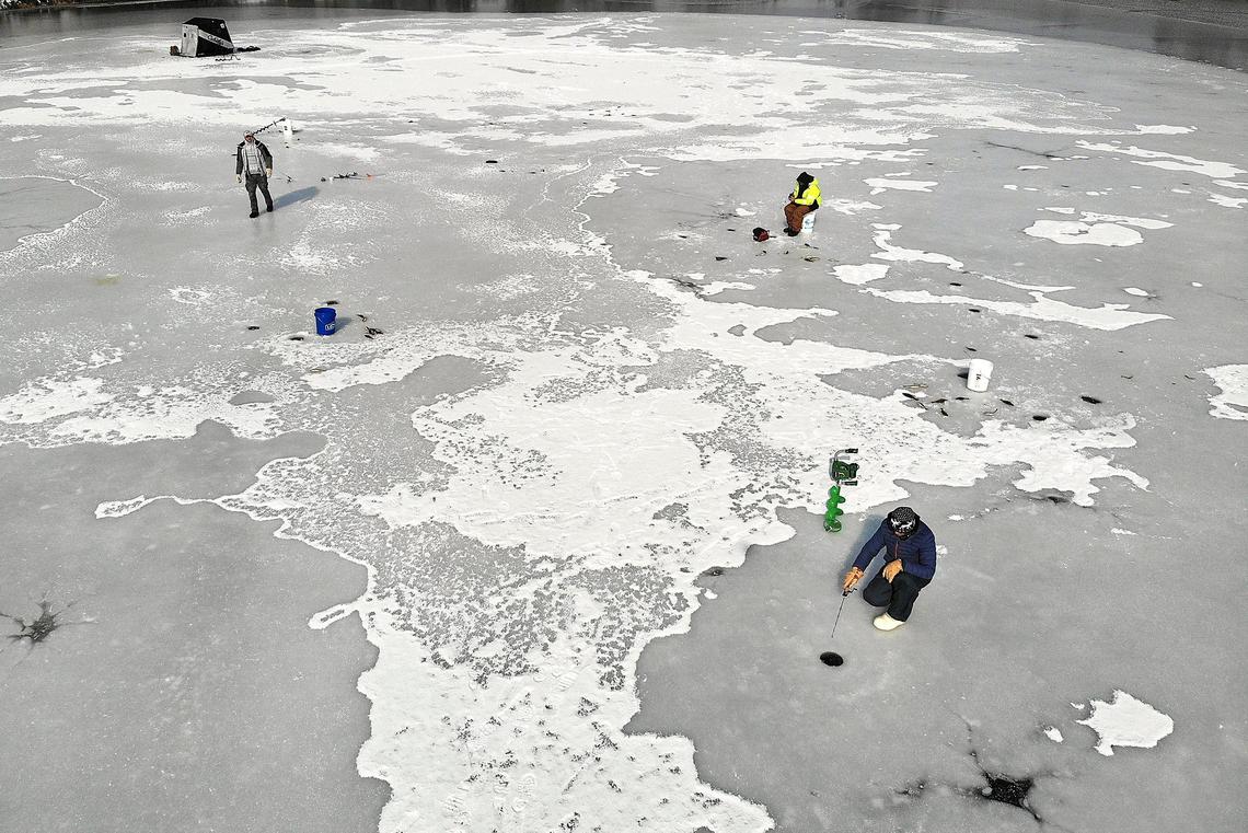 Ice anglers Vlad Kravchyuk, Mike Parkhotyuk and Nate Lisenbee venture onto the frozen Hood Park Boat Basin on Tuesday morning in Burbank. Emergency officials warn the ice is too dangerous to be walking on. Watch a video at: tricityherald.com.video