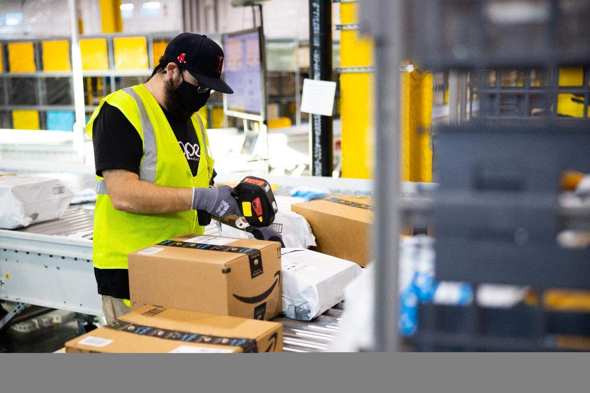A worker sorts through products at an Amazon warehouse.