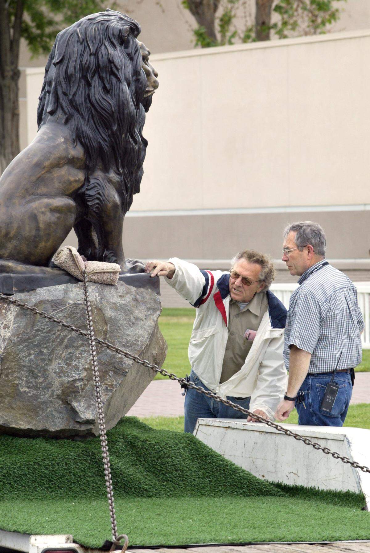 Kennewick businessman and property developer Warren Luke, left, and Ken Smith, Kennewick School District buildings and grounds manager, inspect a bronze lion statue on a trailer in front of Kennewick High School. Luke, who graduated from Kennewick High in 1955, donated the statue.