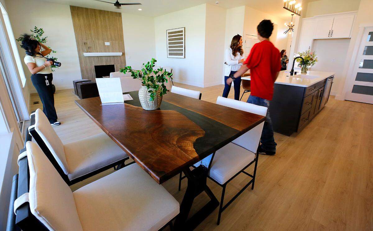 Community members tour the inside of the 25th Team Pasco House built by Pasco students. The custom dining room table also was built by students and was being auctioned during the dedication ceremony.