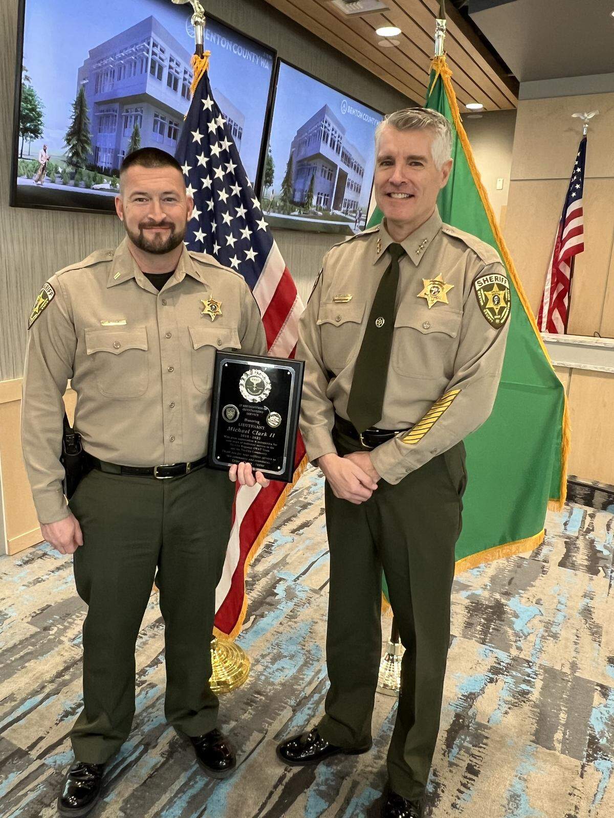 Benton County Sheriff Tom Croskrey, right, presents Lt. Mike Clark with a plaque recognizing his 11 years of service in 2023.