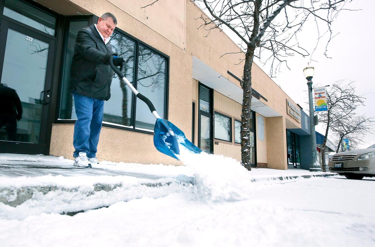 Garry Gorsuch shovels snow from the sidewalk Tuesday morning near his downtown Kennewick business, Awaken Well Chiropractic. An estimated 1-2 inches of snow fell creating slick conditions on area roads and delaying the start of school for many Mid-Columbia students.