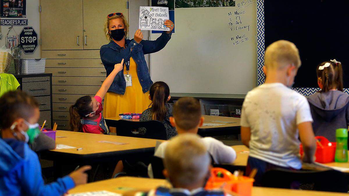 The Pasco School District spent most of its federal COVID relief money on staff wages and benefits. Here, first-grade teacher Valari Benasutti holds up the first assignment of the 2021-22 school year at Rosalind Franklin STEM Elementary School in Pasco.