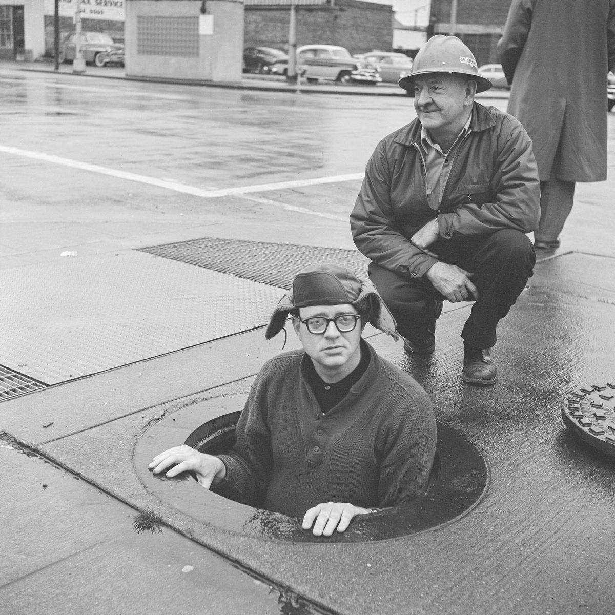 This photo shows tunnel tender Bruce Gordon cautiously poking his head up through a manhole at 4th and Battery while George Gregory looks on. “We are the only groundhogs with an address,” they said, referring to the building at 2339 4th Avenue from which they accessed the tunnel.