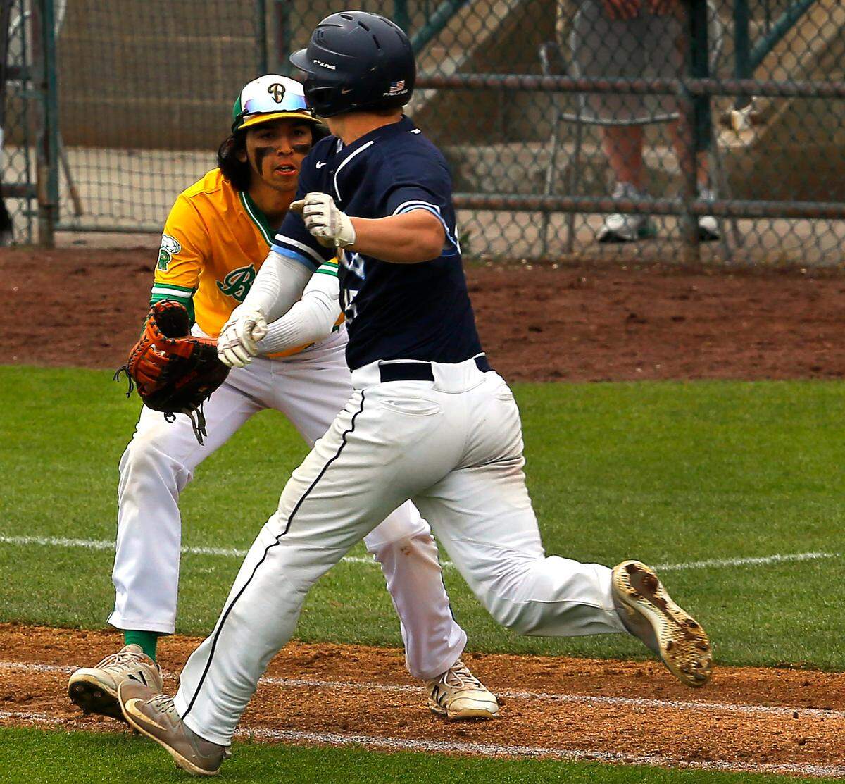 Richland first baseman Troy Molnaa tags out Oylmpia base runner Gabe Downing on a bunt attempt during Friday’s state 4A playoff game in Pasco.