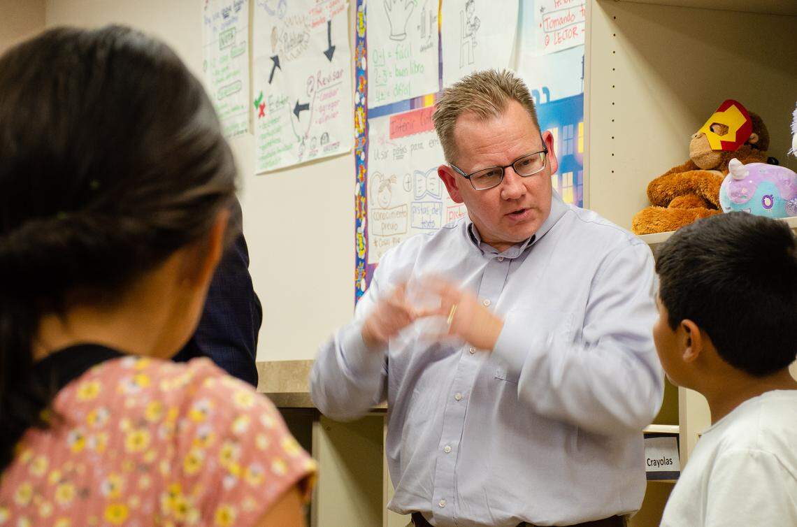 Washington State Superintendent Chris Reykdal speaks to a fourth-grade dual language student in 2022 during a visit to McClintock STEM Elementary school in Pasco,.