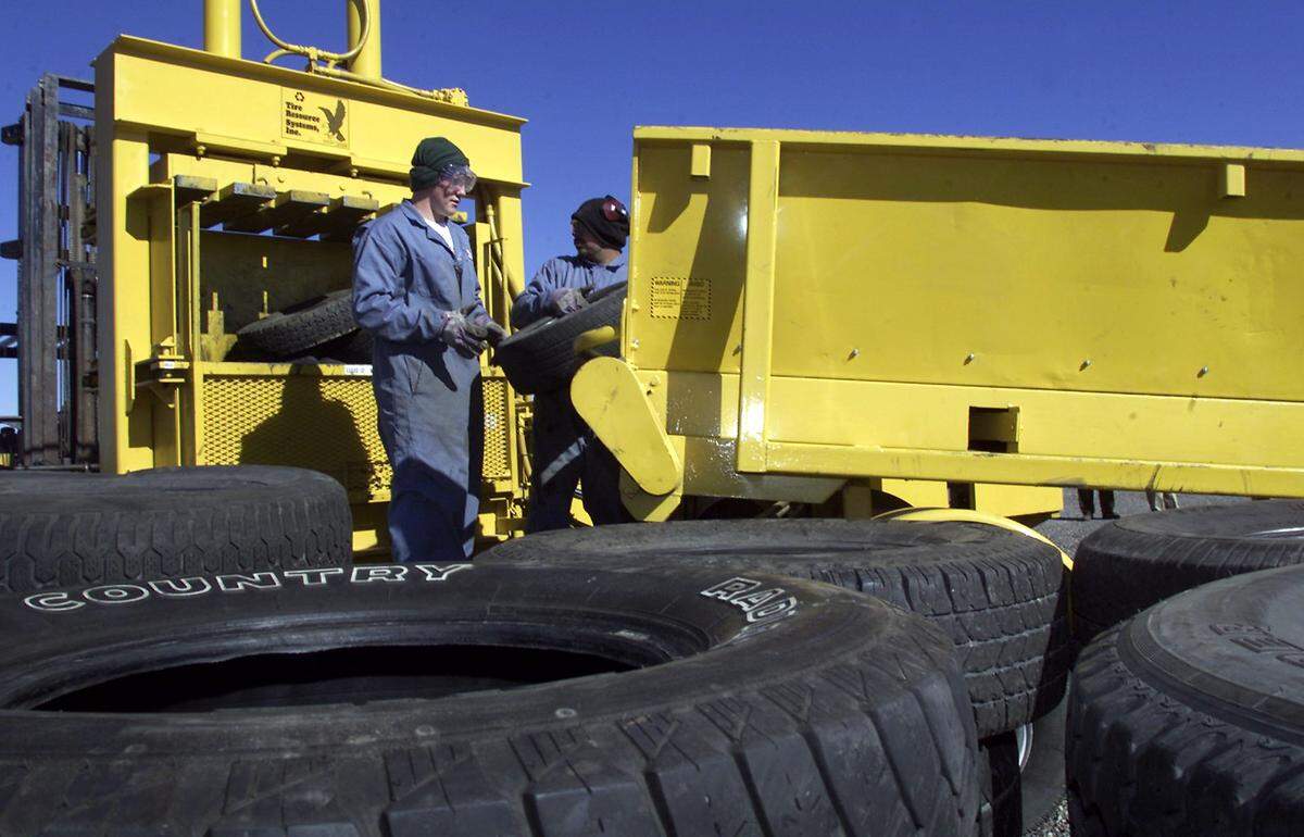Joseph Hankins, left, and Eric Garcia load tires into a machine that compresses them into bales in 2001 at Northwest Tire Recycling Products on Stevens Drive in Richland. The company, owned by Jim and Sherrey Penor, was the only business in Eastern Washington that recycles old tires.