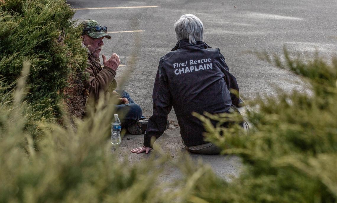 A chaplain speaks to a witness of the Richland Fred Meyer shooting after they were safely escorted out of the building Monday morning.