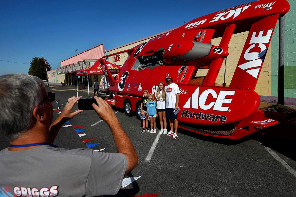 Longtime boat race fan Mark Willer poses with his three daughters, Maggie,10, Annie, 7, and Ren, 12, from left, in front of the U-3 Miss Griggs Ace Hardware unlimited hydroplane as Charlie Grigg takes the photo. It’s the only piston-powered boat. The annual three-day Tri-City Water Follies Columbia Cup races&nbsp;and air show starts Friday on the Columbia River near the blue bridge.