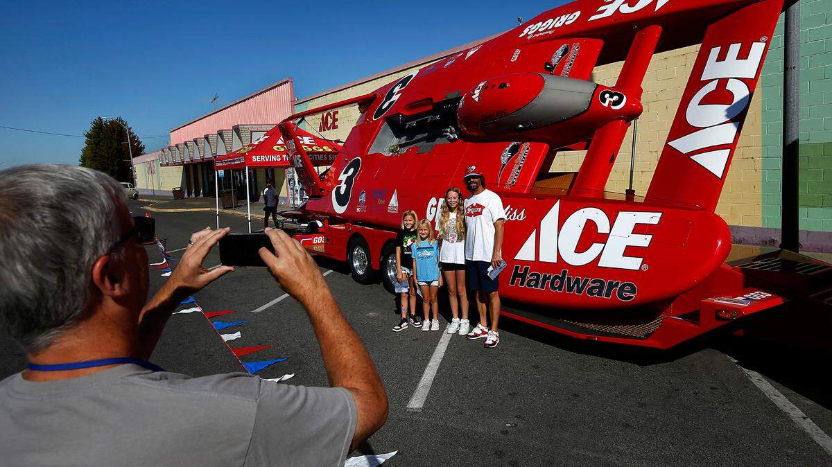 Longtime boat race fan Mark Willer poses with his three daughters, Maggie,10, Annie, 7, and Ren, 12, from left, in front of the U-3 Miss Griggs Ace Hardware unlimited hydroplane as Charlie Grigg takes the photo. It’s the only piston-powered boat. The annual three-day Tri-City Water Follies Columbia Cup races and air show starts Friday on the Columbia River near the blue bridge.