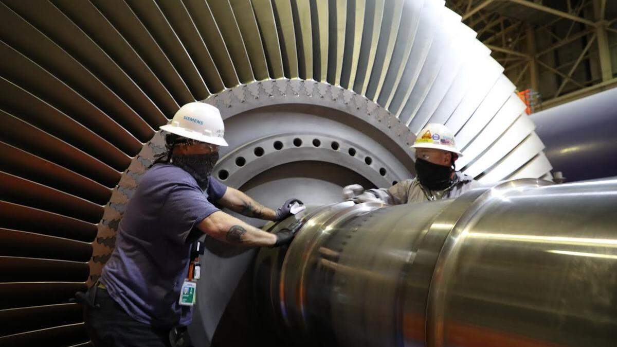 Outage workers Jeremy Zohn, left, of Pasco, and Rip Logan of Oregon clean the low-pressure turbine rotor prior to installation during Columbia Generating Station’s biennial outage. About 1,400 skilled temporary workers were hired to support planned maintenance and refueling.