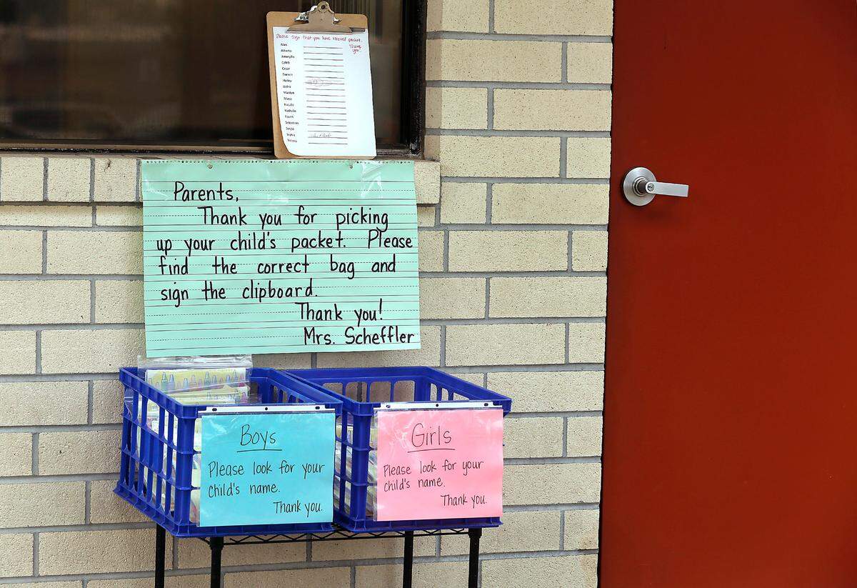 A “contactless” system for parents to pick up student learning packets is set up outside the door of kindergarten teacher Kathy Scheffler’s classroom at Capt. Gray STEM Elementary School in Pasco.