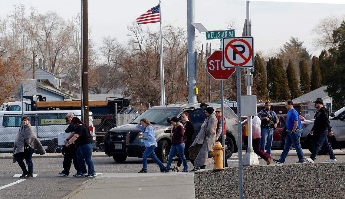 Employees and customers leave after one person was killed and at least one other wounded in a shooting inside the Richland, Wash., Fred Meyer store on Wellsian Way on Monday morning. Police are searching for a suspect.