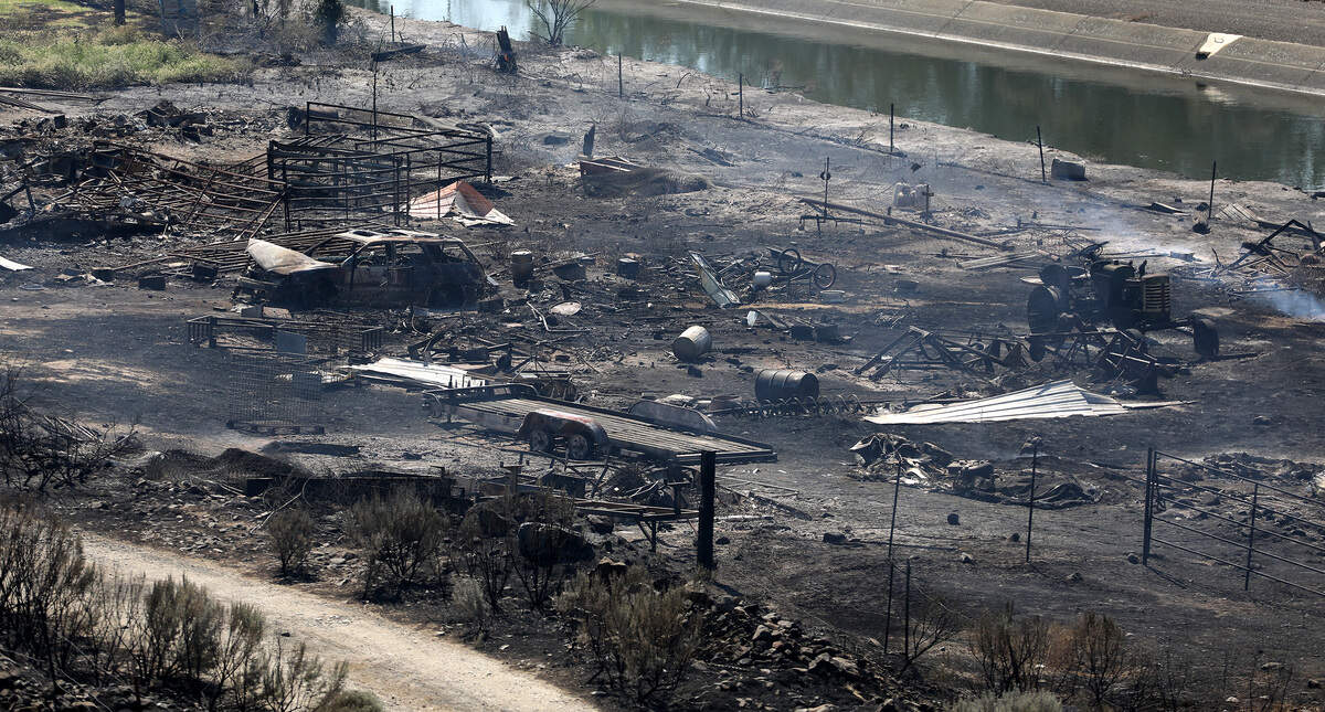 Smoke rises from smoldering hot spots in a burned field near a residence off North District Line Road Monday morning near Prosser.
