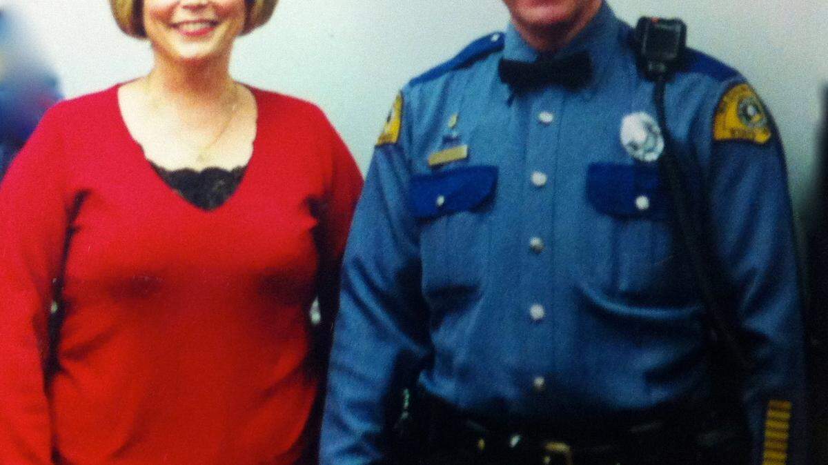 Washington State Highway Patrolman Bill Dingfield and his wife, Ruth, hold hands at an award ceremony for his bravery in the 1994 Fairchild Air Force Base tragedy.