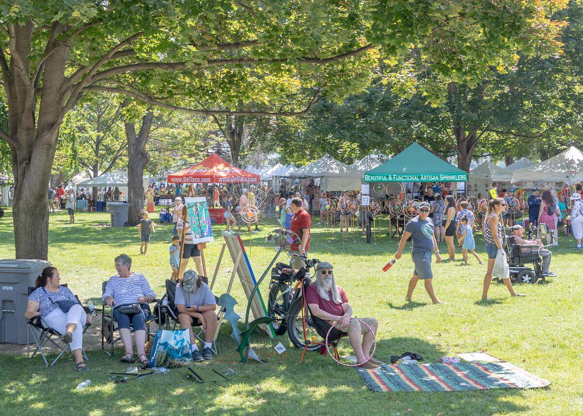 Artists and vendors set up their tent at the Art in the Park festival, attendees are able to view their artworks and set up chairs or blankets under the shade.