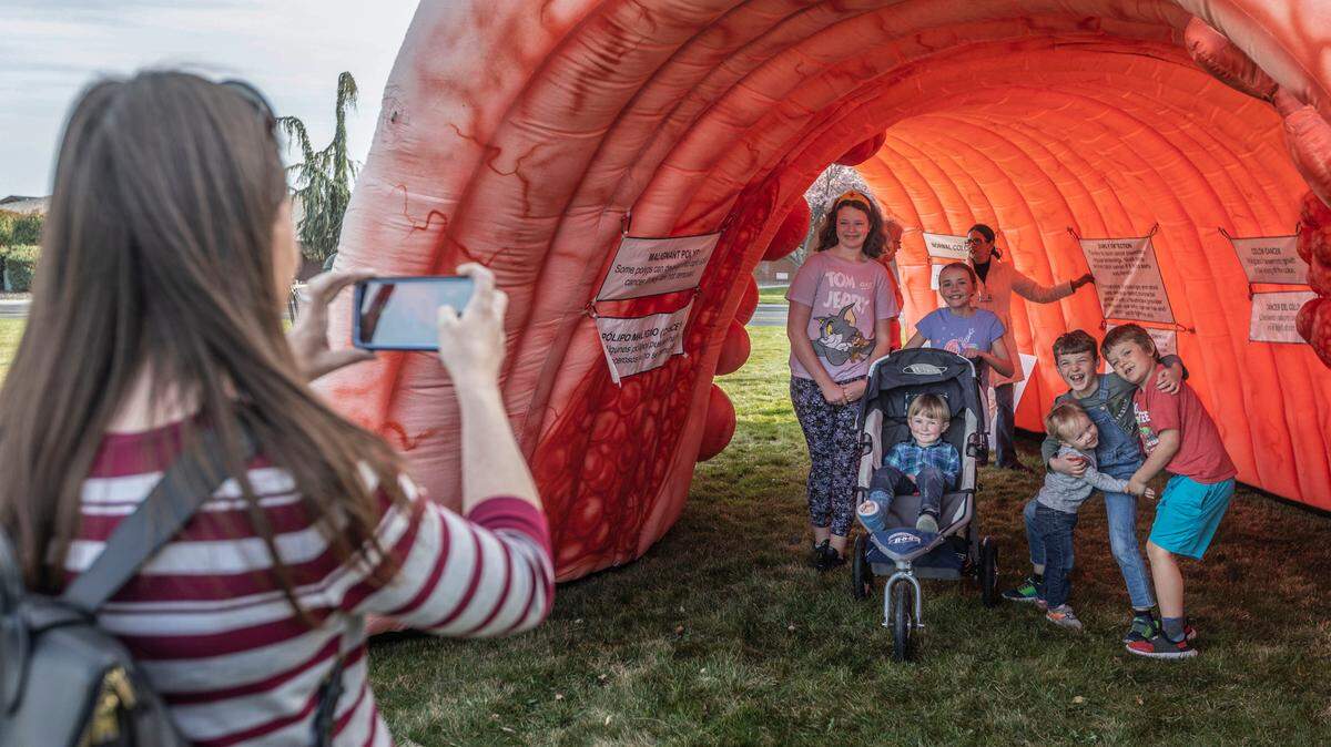 Hilary Ahmann snaps a photo of Averie Soggie, 11, Sam Ahmann, 4, Allie Ahmann, 11, David Ahmann, 2, James Ahmann, 8, and Bear Soggie, 6, inside “Casper the Giant Colon” during a visit to the “Strollin’ Through a Colon” event at the Tri-Cities Cancer Center.