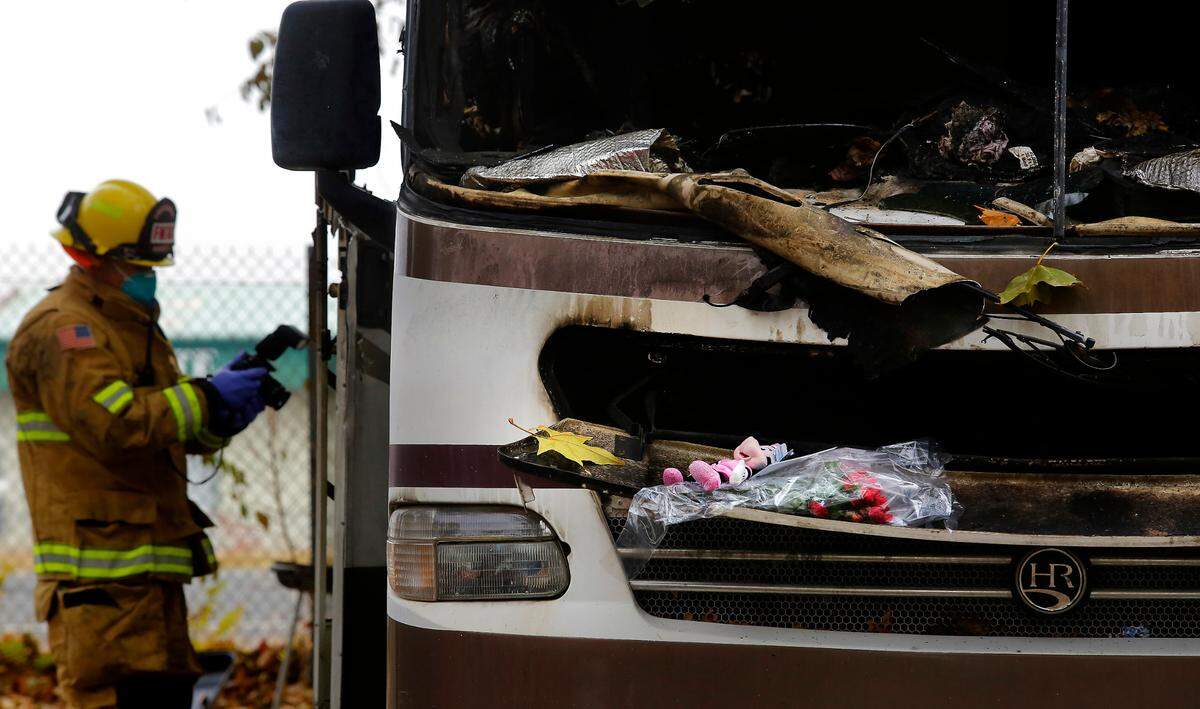 Kennewick Fire investigators document scene while searching Monday for clues to the cause of Saturday’s fatal RV fire that killed Naomi Quetzalli, 8, and critically injured her 14-year-old brother Lotar Jaciel at the Tri-Cities RV Park at 7322 W. Bonnie Ave. in Kennewick. A stuffed Minnie Mouse toy, a card and roses left by well-wishers rests on the front of the heavily damaged motorhome.