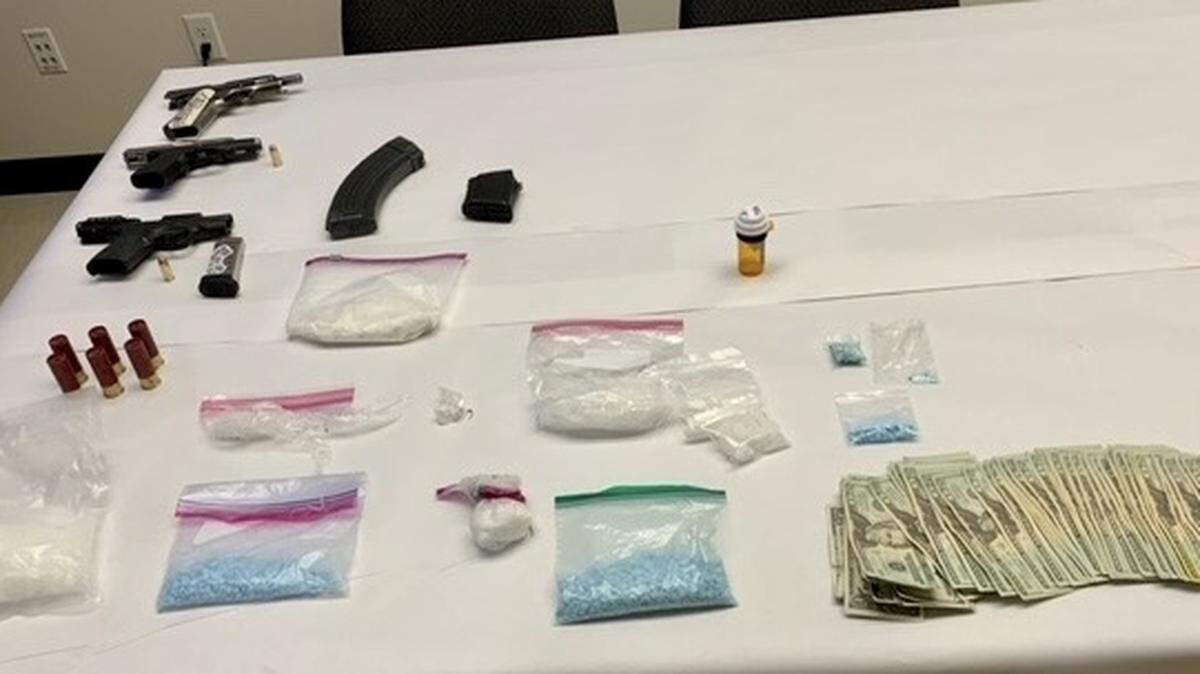 Richland police found cash, guns and drugs while they were searching a home while arresting five people for outstanding warrants.