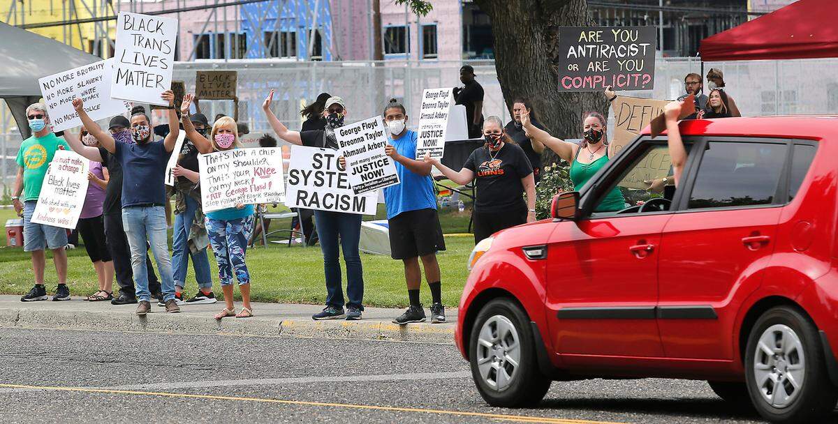 A motorist honks and holds a sign while passing the BLM City Wide Protest on West Sixth Avenue near Kennewick City Hall and the Kennewick Police Department. Another protest, “No Justice, No Peace: One Unified Protest,” drew about 1,000 people to Columbia Center Boulevard on Saturday.