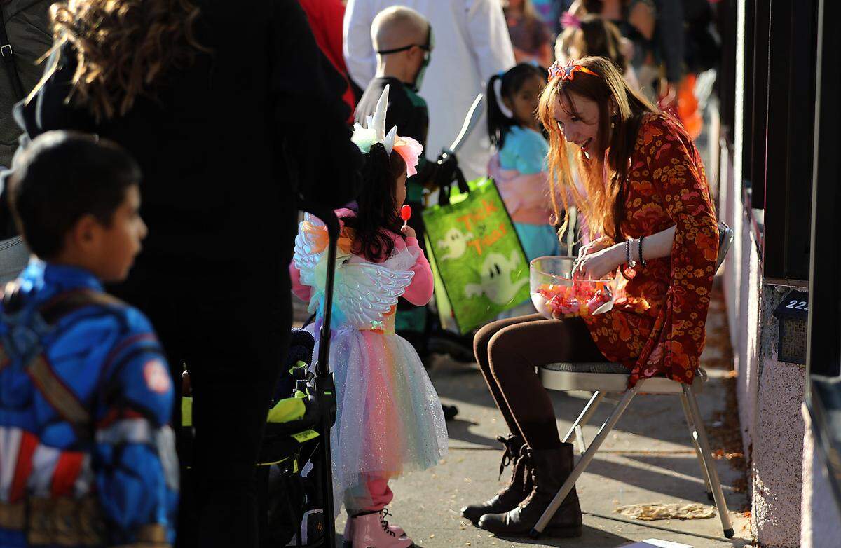 Diedre Cady is all smiles while handing candy to trick-or-treaters during the Downtown Kennewick Halloween Boo Bash. She is the daughter of the owner of Creations Crystals and Healthy LIFE Center.