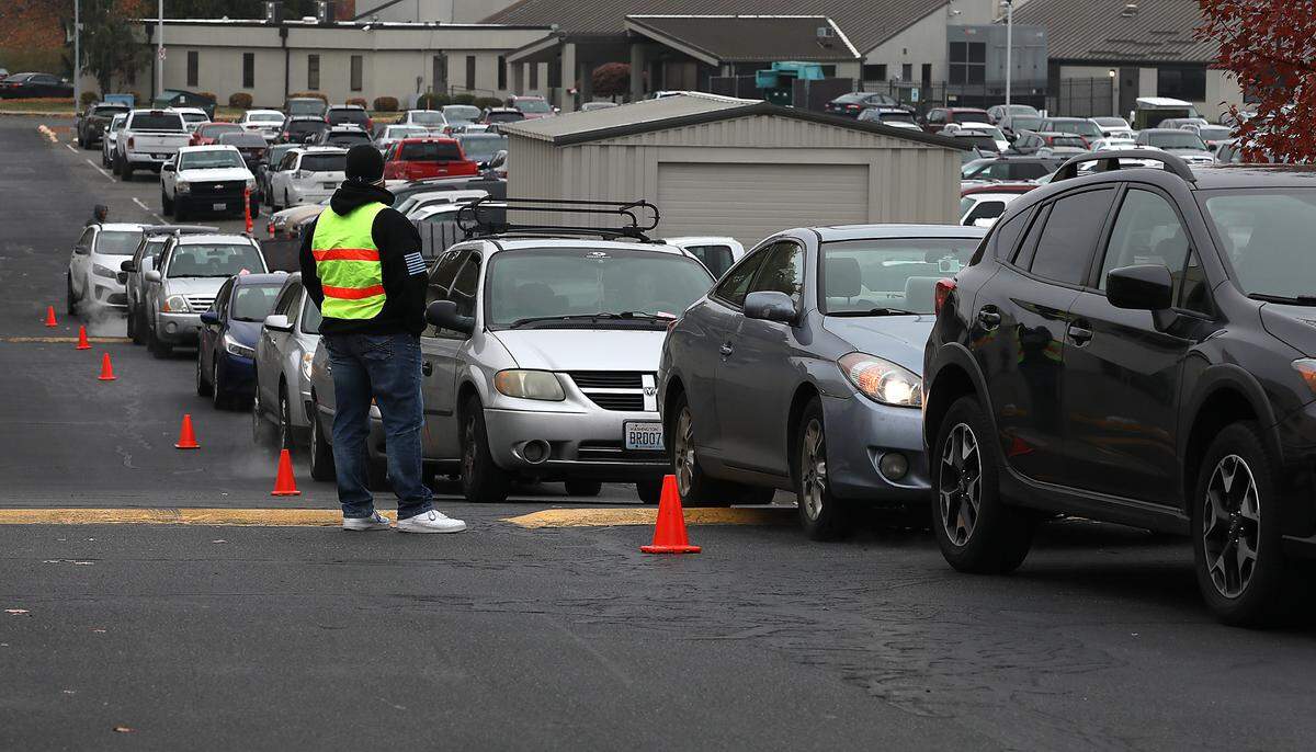 A volunteer helps line up vehicles in the parking lot of the LifeChurch7 in Richland Friday morning for the 2nd Harvest Mobile Market event. About 50 volunteers from the church and Energy Northwest were on hand to help give out free food for about 250 Mid-Columbia families.