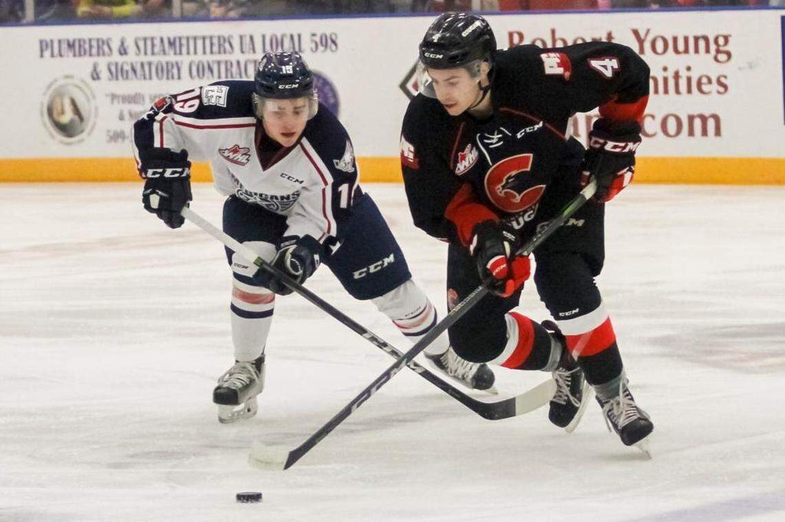Tri-City Americans Tyler Sandhu (19) left, attempts to steal the puck from Joel Lakusta (4) of Prince George during a hockey game on Saturday at Toyota Center in Kennewick.
