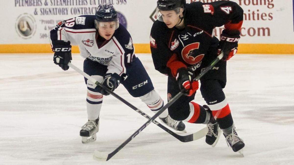 Tri-City Americans Connor Bouchard (19) left, attempts to steal the puck from Joel Lakusta (4) of Prince George during a hockey game on Saturday at Toyota Center in Kennewick.
