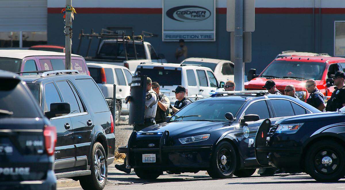 Police officers cautiously approach Gissell Auto Sales on Monday morning in Pasco after the owner of the business discovered a burglar inside the car sales lot office building. Tri-City Regional SWAT team members were called to help arrest him.