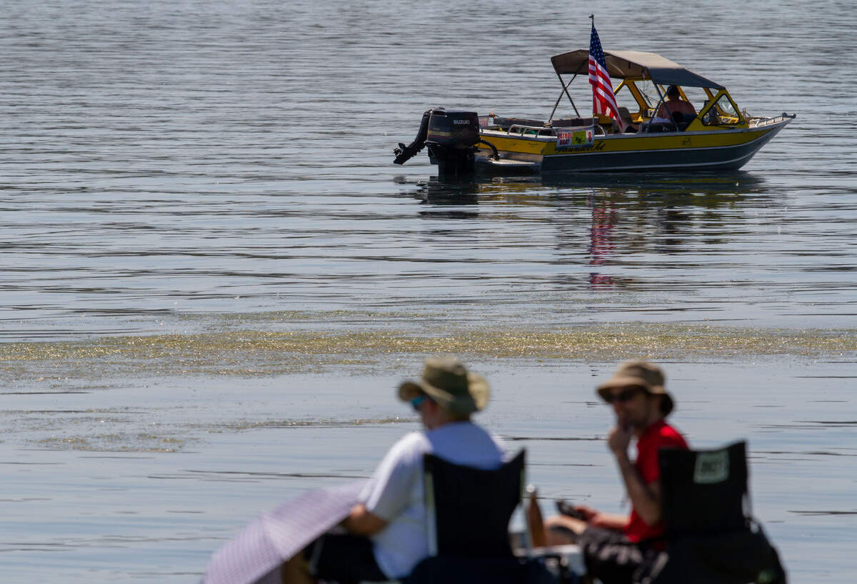 Spectators and a Water Follies patrol boat wait for hydroplane testing to start as vegetation, initially described as milfoil, floats in the Columbia river. Hydroplane testing for this year’s Water Follies was scheduled to begin at 8 a.m. on Friday. But by the early afternoon, testing was called off entirely for the day after a mass of vegetation continued to choke up the river.
