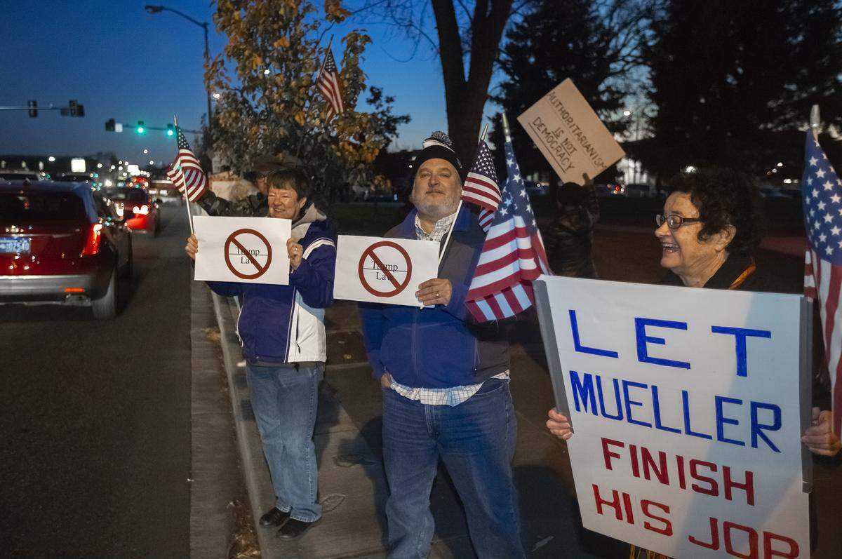 Leslie Wildfong, left, Rick Stachowika, center, and Kay Sison, wave signs and flags along George Washington Way by John Dam Plaza in Richland on Thursday in support of protecting the Mueller investigation. About 300 Tri-Citians showed up during rush hour for the rally.