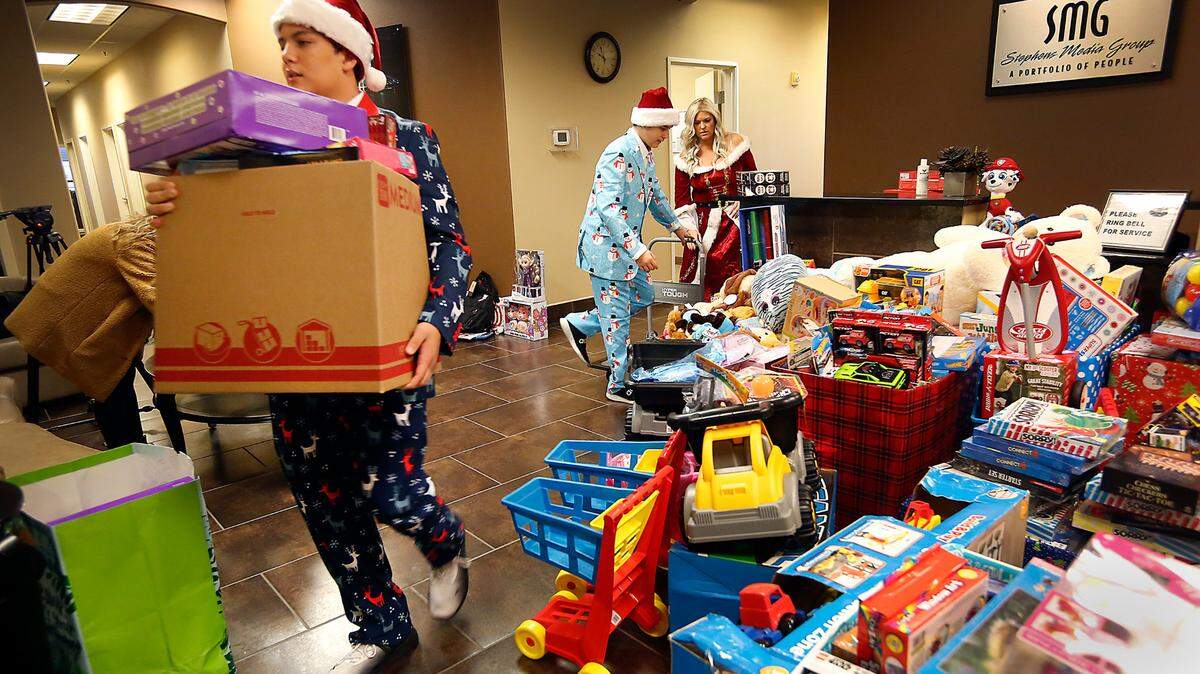 Jazz Little, 14, carries boxes of an estimated 1,500 donated Christmas gifts to a moving truck Wednesday as his brother, Jaxon, 13, and mom, Jennifer “Jen” Little, load gifts for delivery to the pediatric centers at Tri-Cities area hospitals in time for Christmas. The family tradition started over 10 years ago after Jazz was in a hospital and received toys during the holidays. Little, a radio personality at 94.9 The Wolf, starting helping expand the giving with help of her radio listeners and community partners Numerica Credit Union, Speedy Movers, Gregory Drilling and The Kennewick Police Department Foundation.