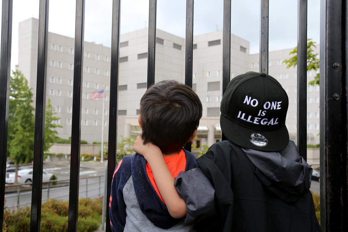 SEATAC, WA - JUNE 09: Javier Tapia (left), age 5, and his brother, Charlie Tapia, age 7, from Seattle, look at a Federal Detention Center holding migrant women on June 9, 2018  in SeaTac, Washington. The boys, whose family is originally from Mexico, were here as part of a protest. Congresswoman Pramila Jayapal visited the Federal Detention Center-SeaTac to meet with more than 100 asylum seekers, many of whom are women. (Photo by Karen Ducey/Getty Images)
