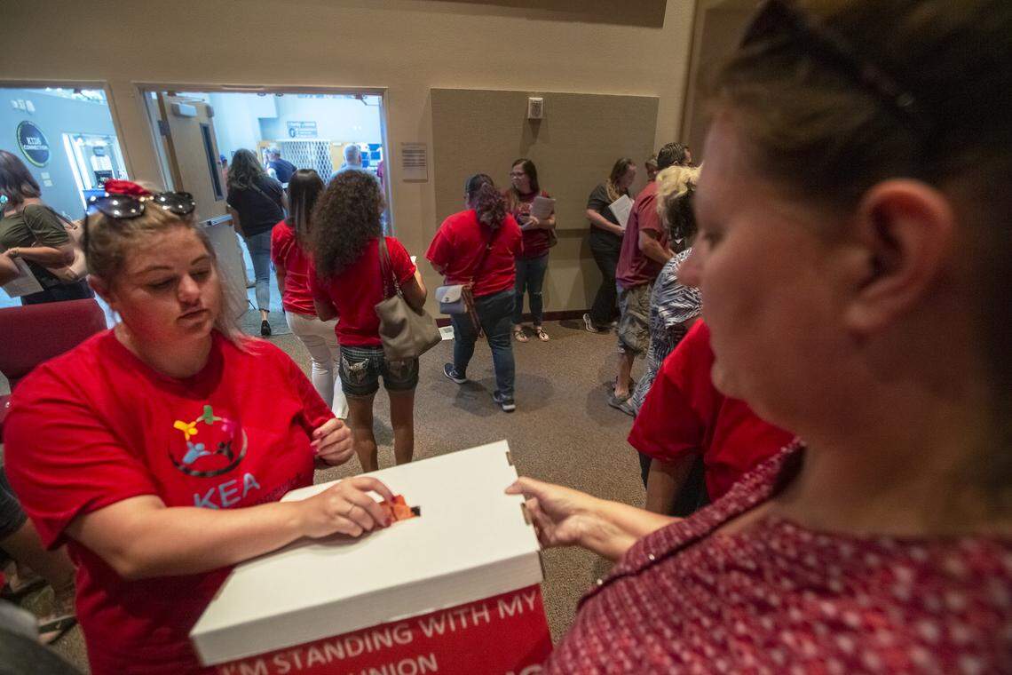 Krysta Beach, left, turns in her vote to Rhona Maclellan during a union meeting at South Hills Church in Kennewick on Friday. The union voted to accept a two-year contract offer that would end the strike/