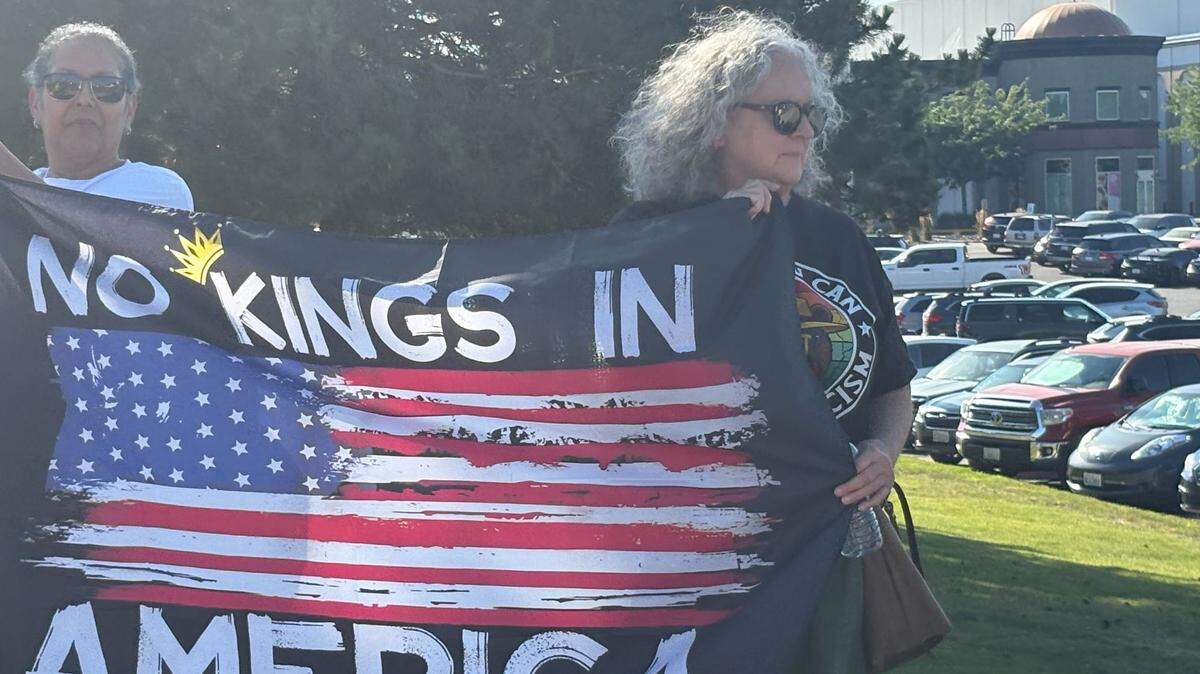 A protester holds a flag reading “No Kings in America” near the entrance to one of the Columbia Center mall parking lots in this July file photo.