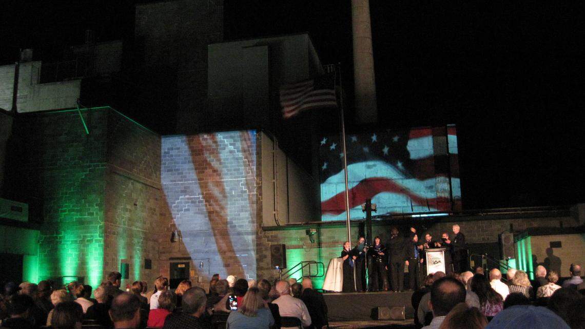 The Mid-Columbia Mastersingers perform "America the Beautiful" as images of the American flag are projected onto the outer walls of B Reactor. The event Friday night marked the 70th anniversary of the startup of Hanford's B Reactor.