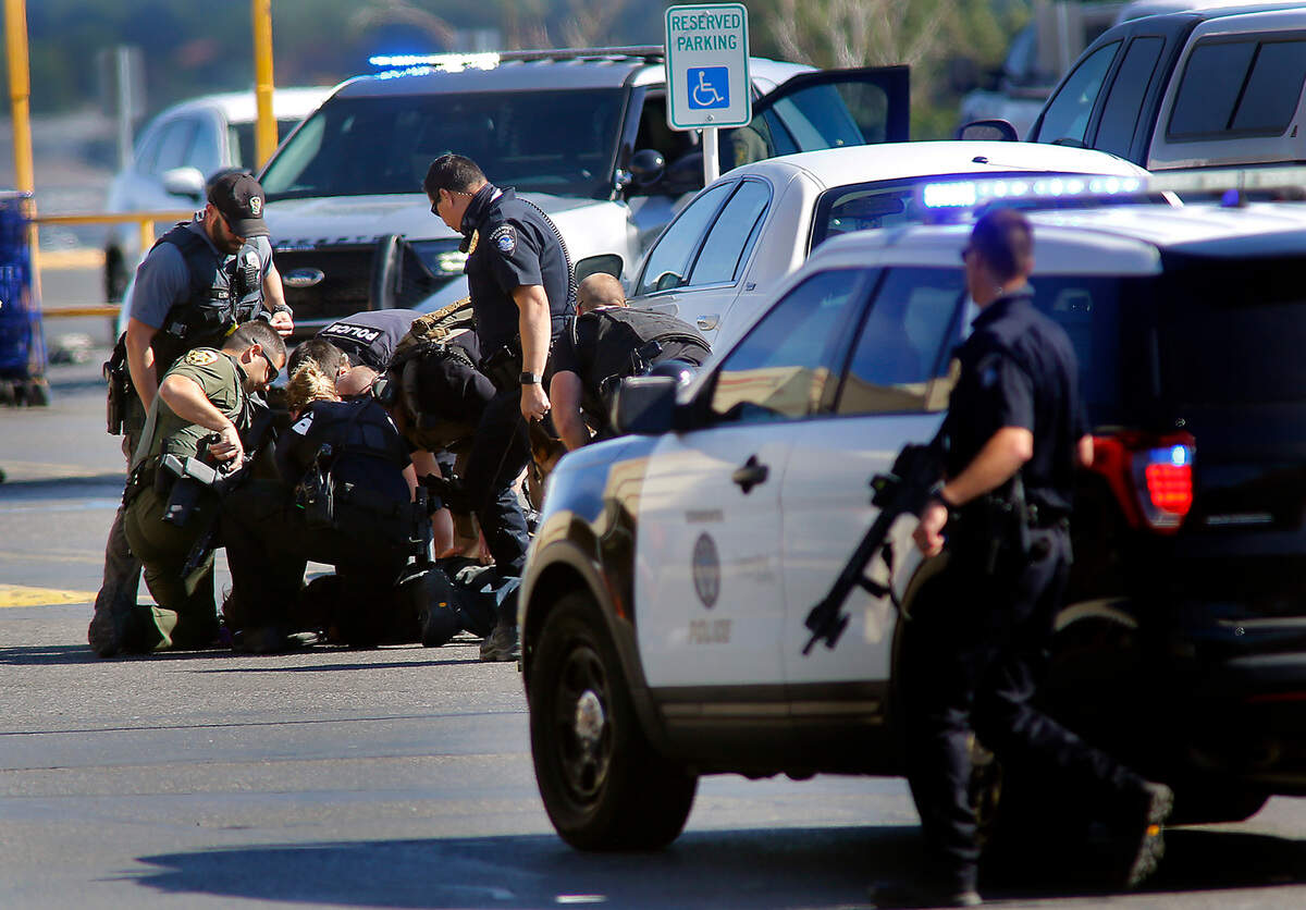 Kerry Brooks, 28, is swarmed to the ground by police officers Wednesday morning in the parking lot of Ranch & Home store on Columbia Center Boulevard in Kennewick. Police say Brooks entered the store brandishing the knife demanding employees sell him a firearm. The employees were able to get Brooks outside the business and lock the doors while calling police. Officers negotiated with him for about an hour before using a non-lethal round to knock the knife from his hand, set off a noise making device as a distraction and then swarm him to safely take him into custody.