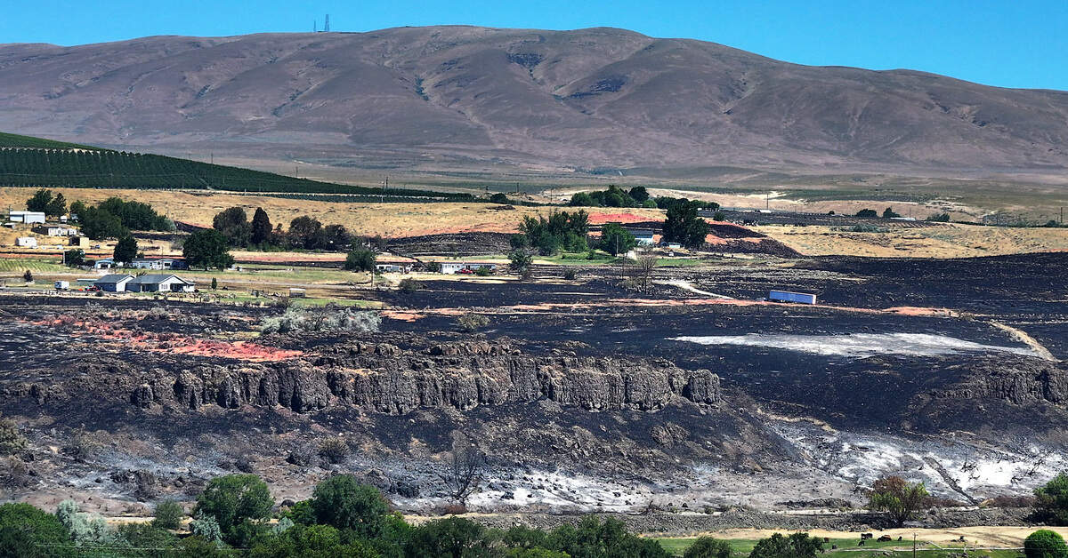The remnants of pink fire retardant are visible on the land above the hills along the Old Inland Empire Highway on Thursday.