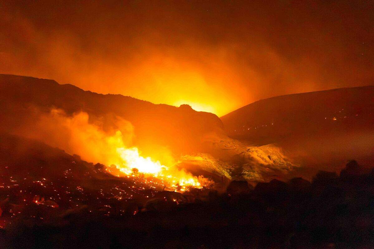 Firefighters battle the Nine Canyon Fire along South Nine Canyon Road early Saturday morning near Kennewick. Strong winds pushed the fast-moving wildfire northeast toward Finley, prompting evacuation notices and bringing in wildland strike teams from across the region.