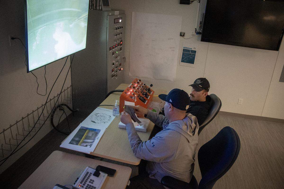 H2C workers Enoc Flores, left, and Trace Martin, right, operate equipment from a control room to remove radioactive salt cake from underground Tank A-102 at the Hanford nuclear site in Eastern Washington.