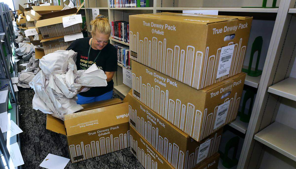 Librarian Elizabeth LeCompte unpacks books in Sageview High School in west Pasco.