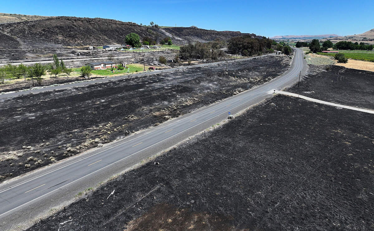 Old Inland Empire Highway has charred land on each side near North District Line Road.