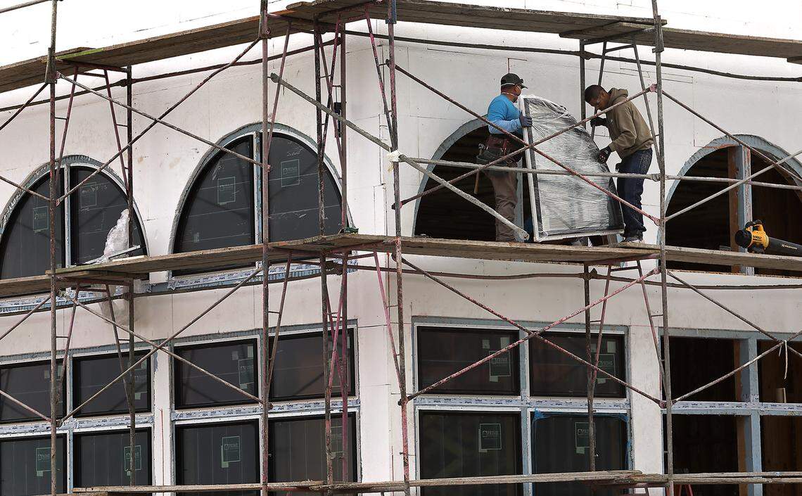 Workers install windows at the new Blueberry Bridal Boutique store being built in the Port of Kennewick's Vista Field area.
