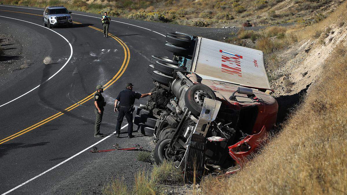 Benton County Sheriff deputies and a Washington State Patrol commercial vehicle officer investigate the rollover crash involving a semi-truck near Benton City.