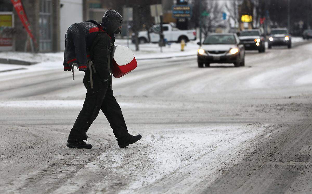 A possible homeless man carries his belongings as he crosses the snow covered intersection of West Clearwater Avenue and South Union Street in Kennewick just days before the annual Point in Time count took place.