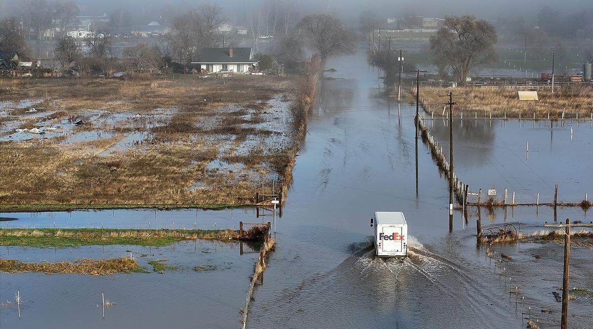 The IRS extended the deadline to file taxes to May 1 after widespread flooding in Western Washington and along the Yakima River in Eastern Washington. Above, a FedEx truck navigates floodwaters on Jones Road in Richland. 