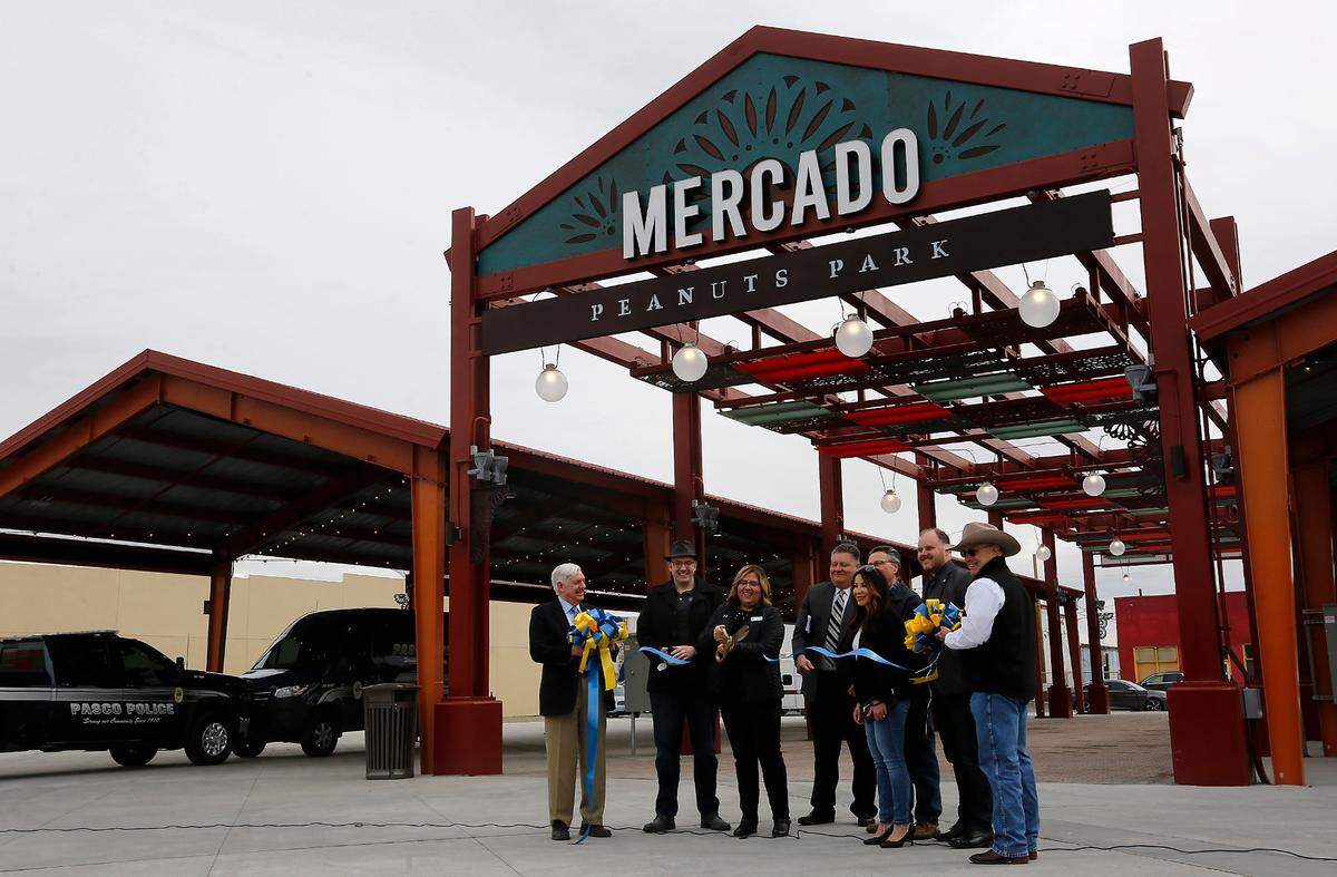Pasco Mayor Blanche Barajas performs the official ribbon cutting while joined by other council members and dignitaries during Friday’s ceremony for the newly renovated Peanuts Park and Farmers Market in downtown Pasco. About 200 people attended the outdoor event.