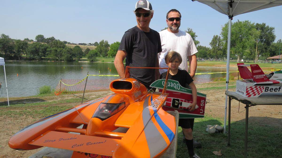 Jim (left), Adam and Bradley Putich stand with one of their radio controlled racing boats at the RC Unlimiteds event at the Tri-City Water Follies.